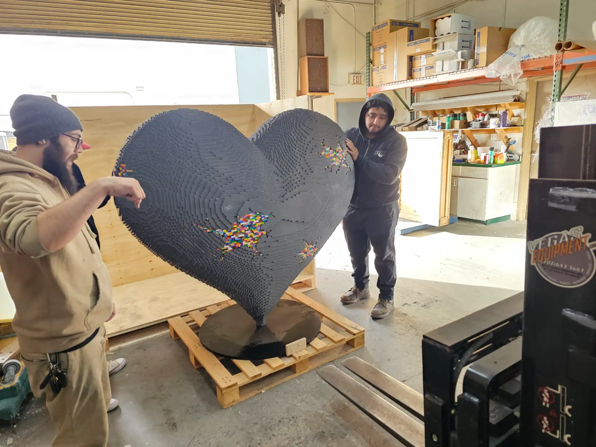Staff consulting on a large custom Lego heart sculpture